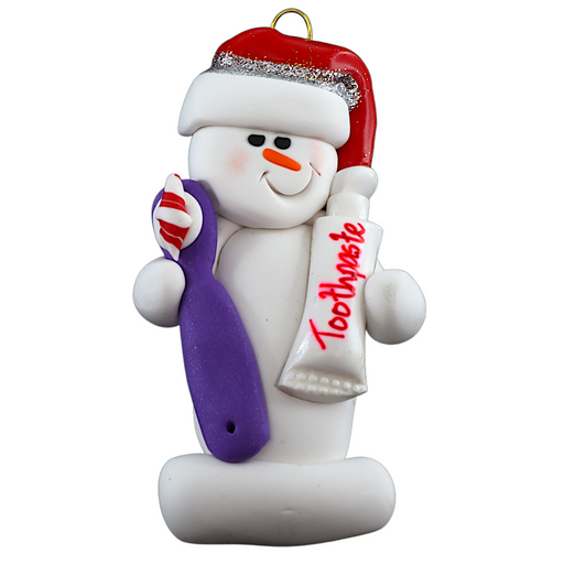 Ornament of white snowman in red hat holding a toothbrush and toothpaste.