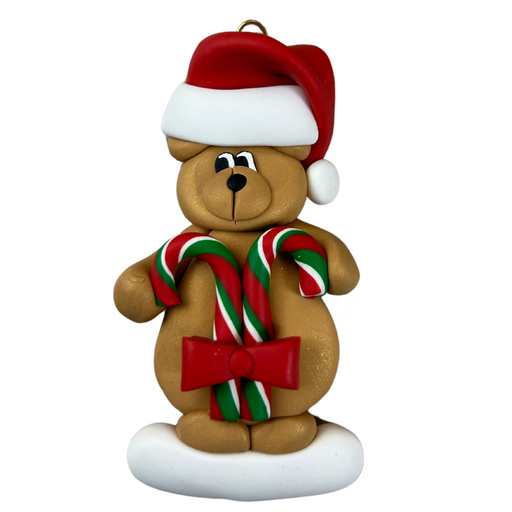 Tan bear in red festive hat holding two candy canes ornament.