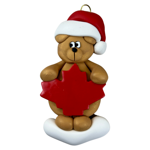 Tan bear in red festive hat with maple leaf ornament.