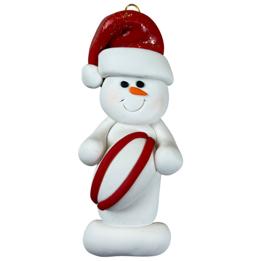 Ornament of white snowman in red hat holding a red and white rugby ball.
