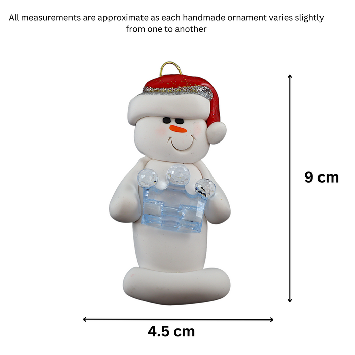 Ornament of white snowman in red hat holding a blue plastic crown, graphed to show size (4.5x9cm).