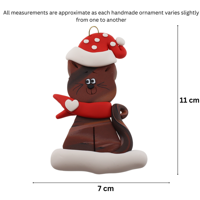 Ornament of brown cat in red and white polka dot Christmas hat and scarf, graphed to show size (7x11cm).