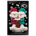 Ornament of snowman couple in red and green shirts and hats with a brown cat in Christmas hat, on a display backing card.