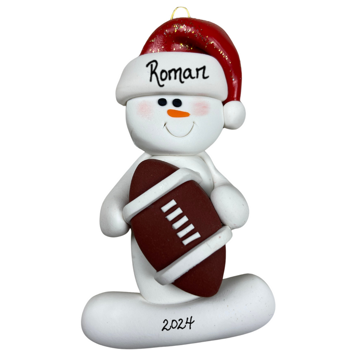 Ornament of white snowman in red hat holding a football, personalized with name.