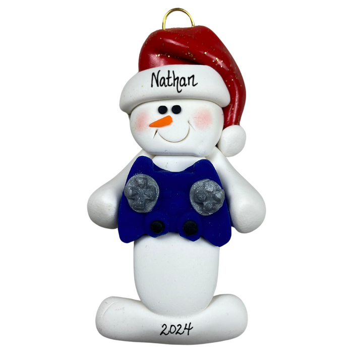 Ornament of white snowman in red hat holding a blue video game controller, personalized with name.