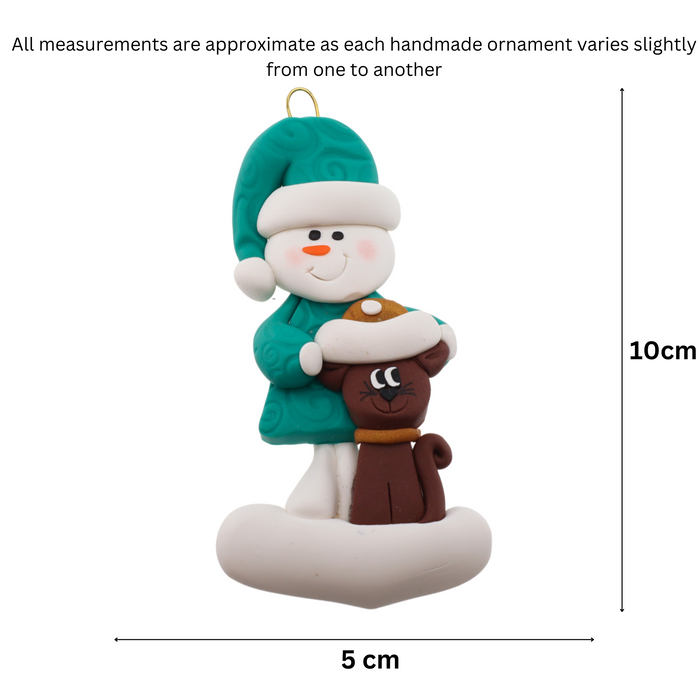 Ornament of snowman in a green shirt and hat with brown cat in Christmas hat, graphed to show size (5x10cm).