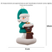 Ornament of snowman in a green shirt and hat with brown cat in Christmas hat, graphed to show size (5x10cm).